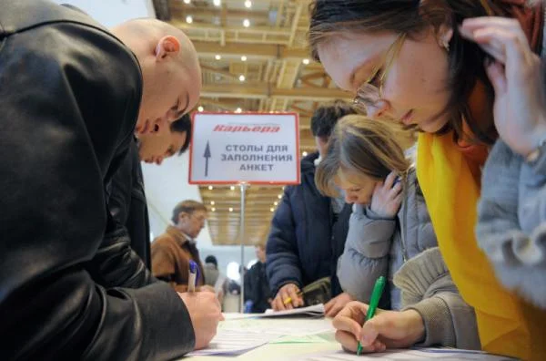 молодые люди заполняют анкеты на ярмарке вакансий