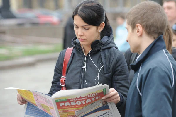 девушка просматривает вакансии в газете работа