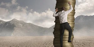 мужчина офисный работник забирается на стопку из монет