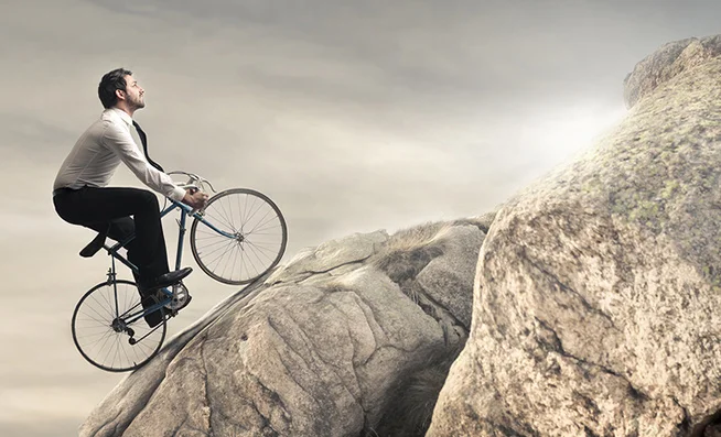 офисный работник на велосипеде забирается в гору