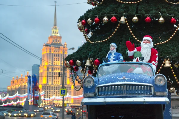 дед мороз и снегурочка в автомобиле под новогодней елкой