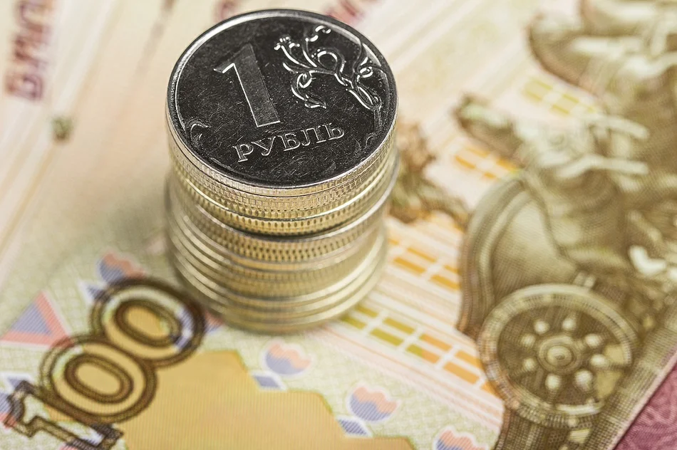 несколько металлических рублей на сторублевой купюре