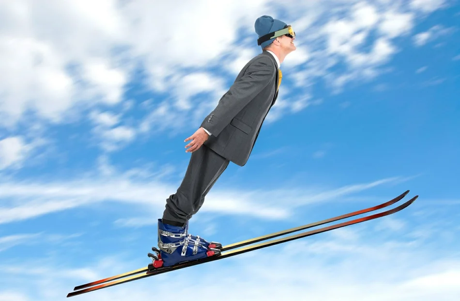 мужчина в костюме прыгает на лыжах