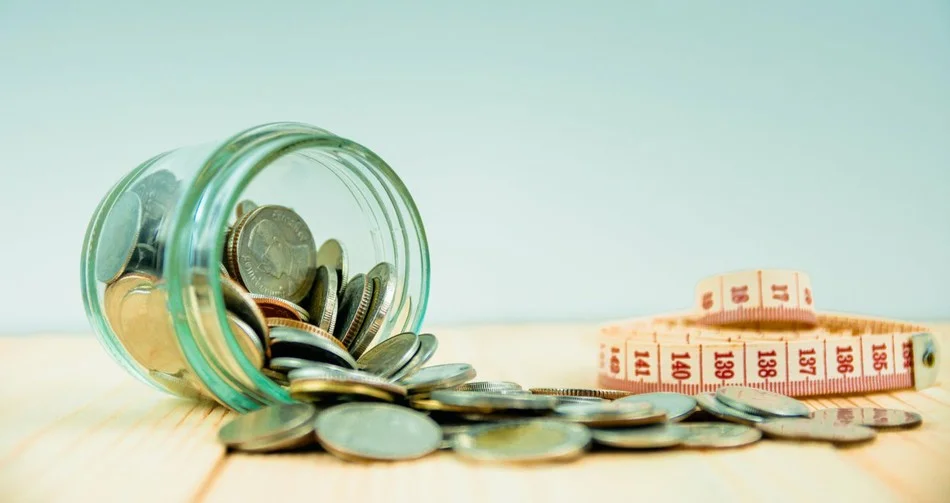 денежные монеты высыпались из стеклянной банки на столе рядом с метром