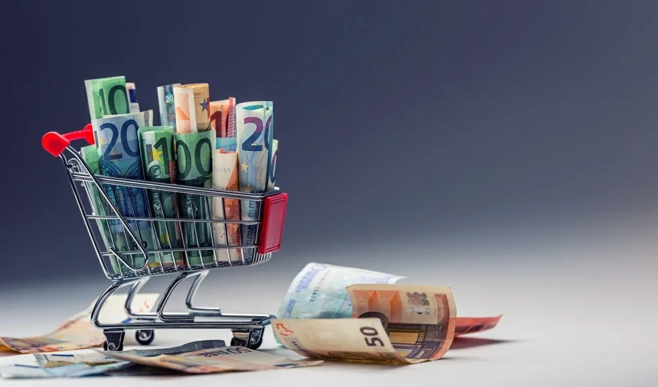 свернутые купюры евро в тележке из супермаркета