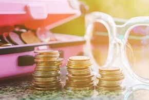 на столе перед очками стопки золотых монет