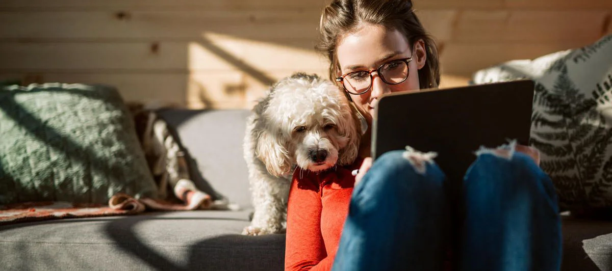 девушка с планшетом и собачкой проходит собеседование удаленно