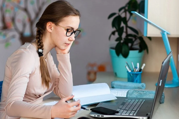 девушка офисный работник за ноутбуком решает задачу