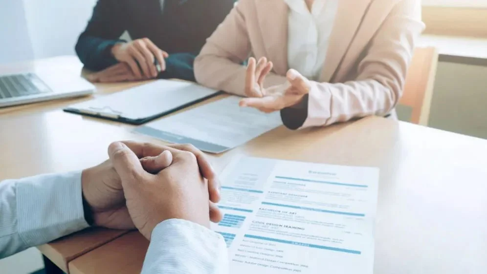 женщина в деловом костюме проводит интервью с соискателем