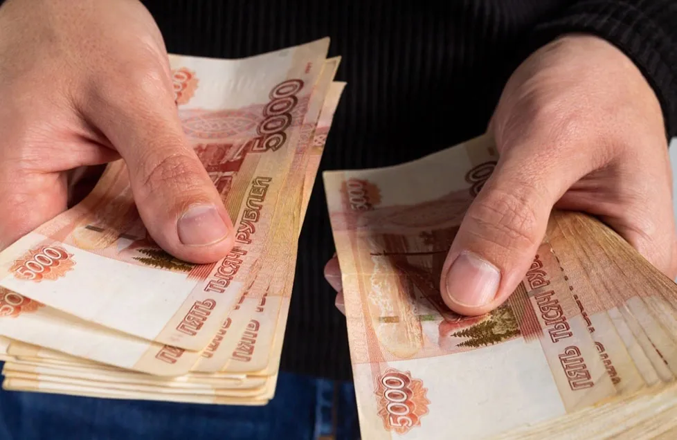 пятитысячные купюры в руках