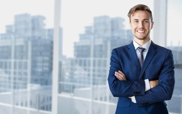 Мужчина генеральный директор стоит в офисе на фоне зданий