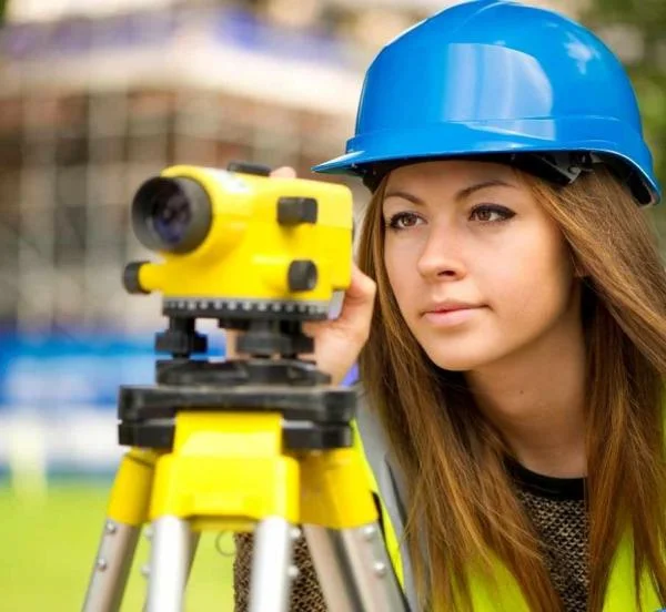 Девушка Инженер-Геодезит с прибором для геодезической съемки 