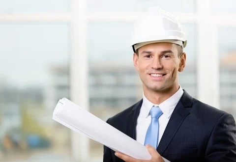 Мужчина главный инженер в каске с чертежом