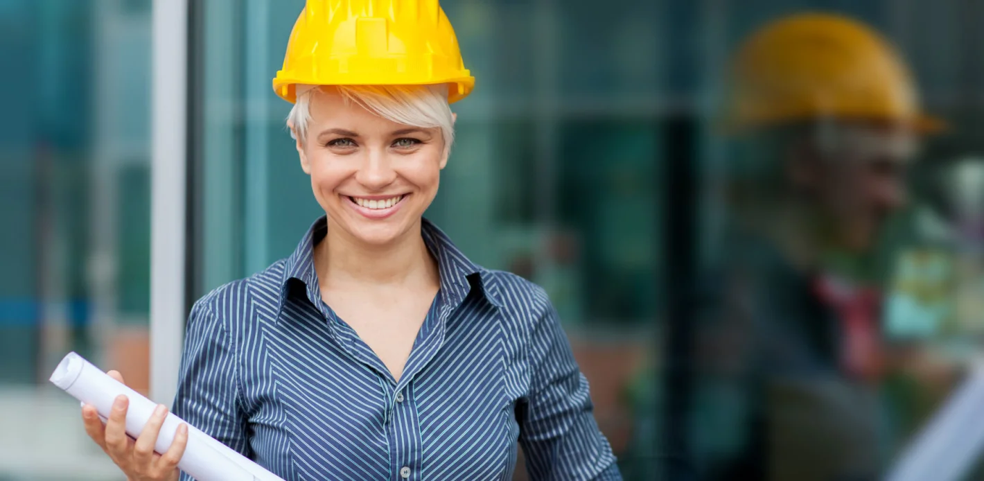 Девушука инженер-сметчик с чертежом на фоне стекла