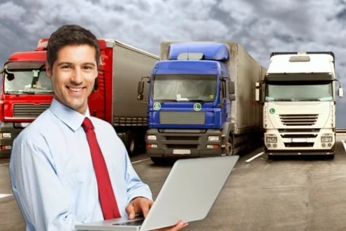 Мужчина логист стоит с ноутбуком на фоне автомобилей