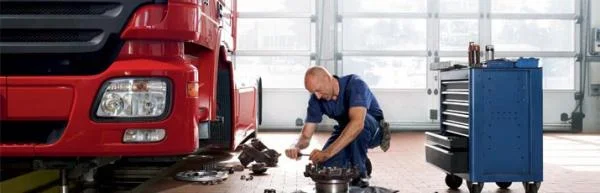 Мужчина механик работает с деталями грузовика