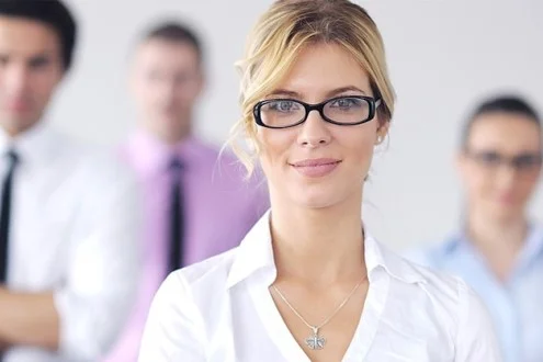 Девушка менеджер по персоналу в очках на фоне сотрудников