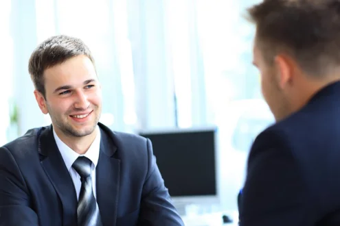 Мужчина менеджер по продажам улыбается собеседнику на переговорах в офисе