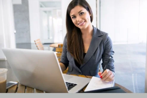 Девушка менеджер по размещению заказов делает запись в тетрадь