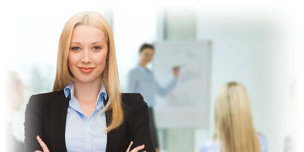 Девушка руководитель отдела маркетинга стоит в офисе на фоне сотрудников