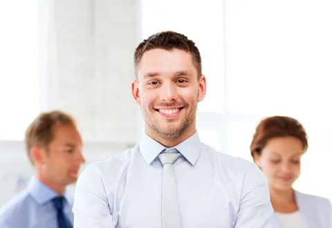 Мужчина руководитель сервисного центра стоит в офисе на фоне сотрудников