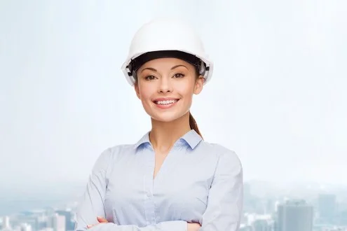 Девушка ведущий инженер ПТО в каске на фоне города